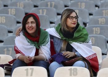 Iranian women wear their country's flag on their shoulders at the Azadi Stadium for the 2022 World Cup Qualifier soccer match between Iran and Cambodia