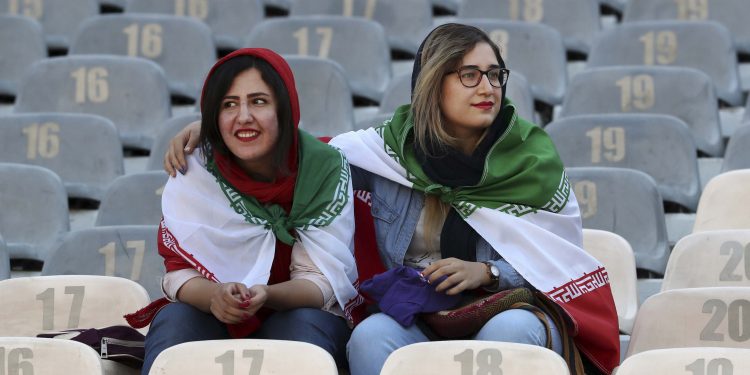 Iranian women wear their country's flag on their shoulders at the Azadi Stadium for the 2022 World Cup Qualifier soccer match between Iran and Cambodia