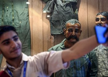 A student takes a selfie in front of the statue of Indian pilot Wing Commander Abhinandan Varthaman (2R) whose plane was shot down over Kashmir earlier this year, put on display at Pakistan Air Force Museum in Karachi on November 12, 2019. (Photo by Asif HASSAN / AFP)