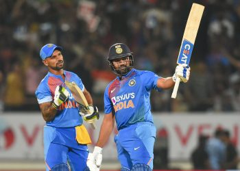 India's stand-in captain Rohit Sharma  raises his bat after reaching his half century against Bangladesh as fellow opener Shikhar Dhawan watches