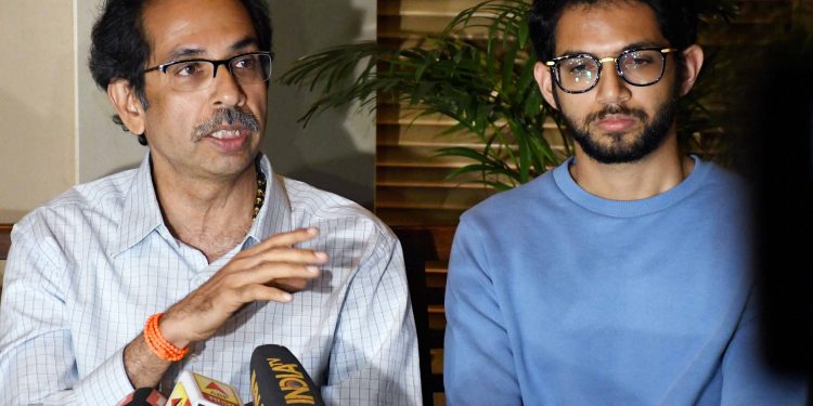 Shiv Sena chief Uddhav Thackeray addresses a press conference as his son and Yuva Sena chief Aaditya Thackeray looks on