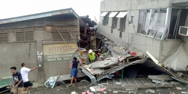 Rescue crew members look for trapped victims at collapsed building at Padada market, in Padada  Philippines December 15, 2019 in this still image obtained from social media video. VINCENT YAJ MAKIPUTIN/via REUTERS THIS IMAGE HAS BEEN SUPPLIED BY A THIRD PARTY. MANDATORY CREDIT. NO RESALES. NO ARCHIVES.