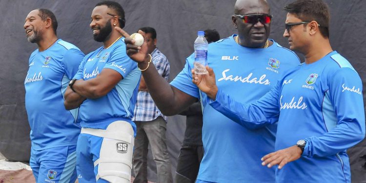 Kieron Pollard (2nd left) has a laugh with Phil Simmons