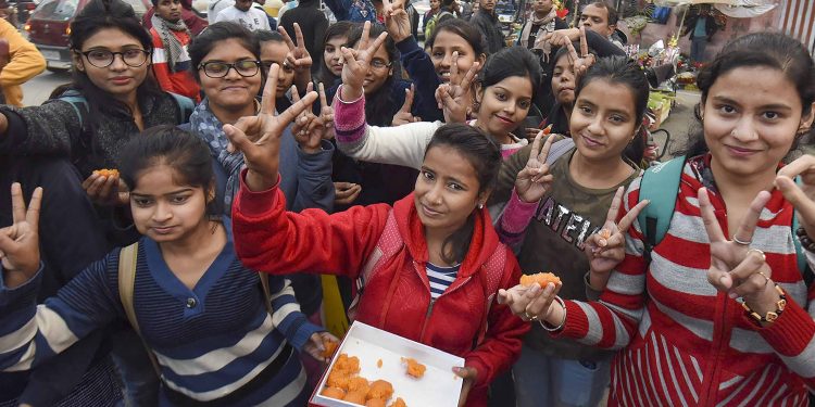 Children distribute sweets after the announcement of the verdict in the Nirbhaya gangrape case