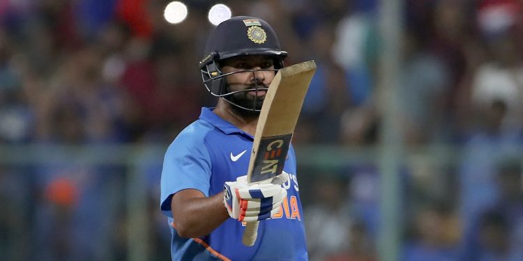 Rohit Sharma raises his bat after reaching his century at Bangalore against Australia