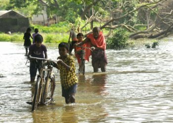 File photo of villagers wading through a flooded street at Banki in Cuttack