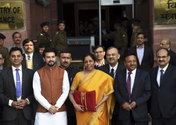 Union Finance Minister Nirmala Sitharaman, holding a folder containing Budget documents, poses for photographers along with her deputy Anurag Thakur and other officials