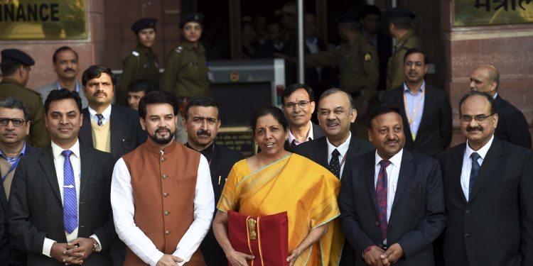 Union Finance Minister Nirmala Sitharaman, holding a folder containing Budget documents, poses for photographers along with her deputy Anurag Thakur and other officials