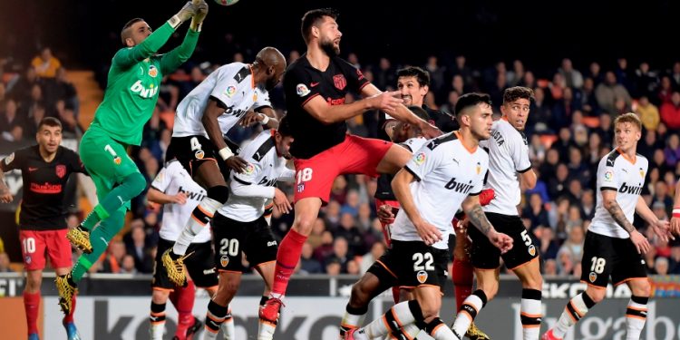 Valencia's Spanish goalkeeper Jaume Domenech (L) jumps for the ball during the Spanish league football match between Valencia CF and Club Atletico de Madrid at the Mestalla stadium in Valencia on February 14, 2020. (Photo by JOSE JORDAN / AFP)