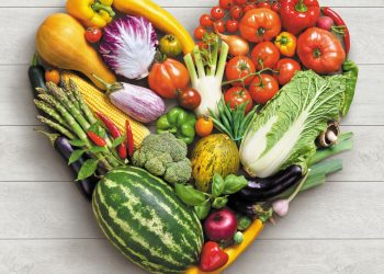 Heart symbol. Vegetables diet concept. Food photography of heart made from different vegetables on white wooden table. High resolution product.