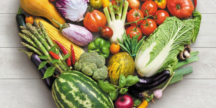 Heart symbol. Vegetables diet concept. Food photography of heart made from different vegetables on white wooden table. High resolution product.