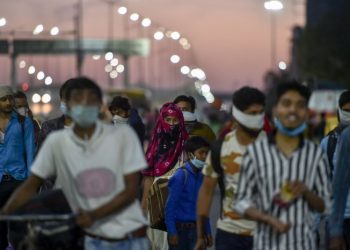 Migrants, along with their family members, walk to their villages amid the nationwide lockdown, in the wake of coronavirus pandemic, at Delhi-Uttar Pradesh border. (PTI Photo)