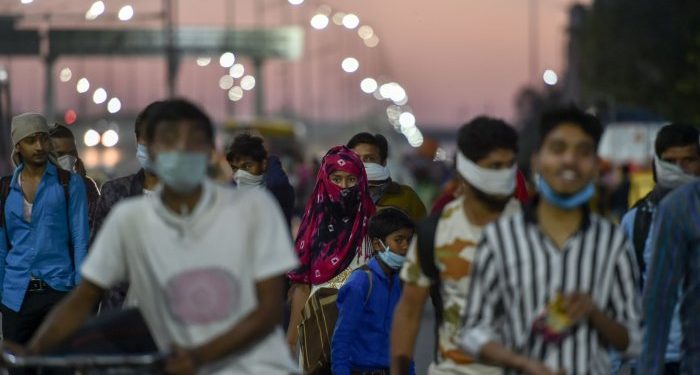 Migrants, along with their family members, walk to their villages amid the nationwide lockdown, in the wake of coronavirus pandemic, at Delhi-Uttar Pradesh border. (PTI Photo)