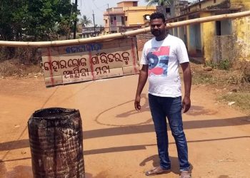 A volunteer guards the entry point of Totapada village under Khurda block