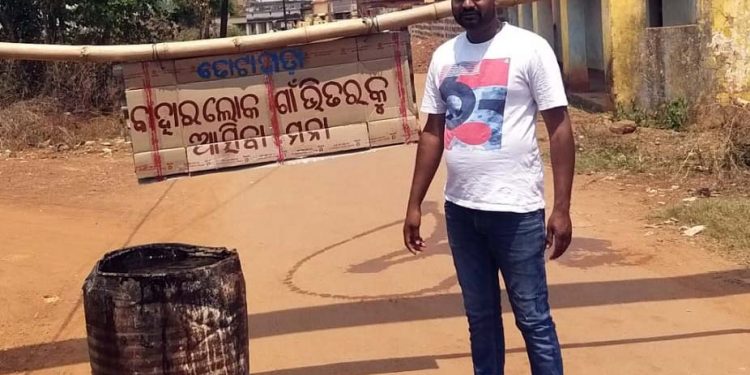 A volunteer guards the entry point of Totapada village under Khurda block