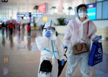 A lady and her son at the Wuhan Airport, Wednesday