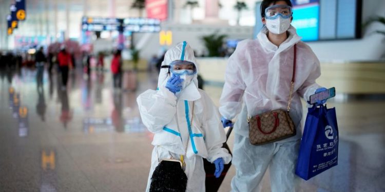 A lady and her son at the Wuhan Airport, Wednesday