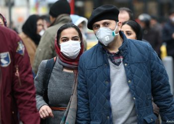 Iranian couple wearing protective masks to prevent contracting a coronavirus walk at Grand Bazaar in Tehran, Iran February 20, 2020. WANA (West Asia News Agency)/Nazanin Tabatabaee via REUTERS ATTENTION EDITORS - THIS IMAGE HAS BEEN SUPPLIED BY A THIRD PARTY. - RC2D4F91Q0H7