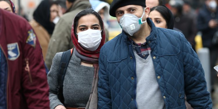 Iranian couple wearing protective masks to prevent contracting a coronavirus walk at Grand Bazaar in Tehran, Iran February 20, 2020. WANA (West Asia News Agency)/Nazanin Tabatabaee via REUTERS ATTENTION EDITORS - THIS IMAGE HAS BEEN SUPPLIED BY A THIRD PARTY. - RC2D4F91Q0H7