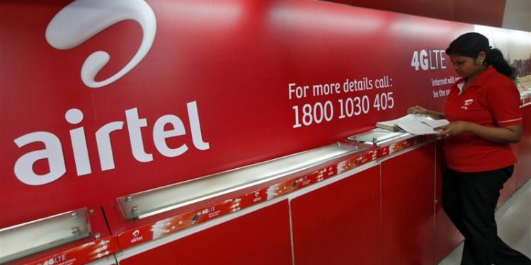 An employee checks a customers' feedback book next to a Bharti Airtel logo inside its shop in Kolkata May 2, 2012. REUTERS/Rupak De Chowdhuri/Files