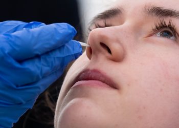 23 March 2020, Bavaria, Munich: Medical personnel demonstrate the collection of a nasal swab in a new test station in front of the Tropical Institute for people suspected of having Covid-19. Only medical personnel and specific professional groups such as the police or fire brigade will be tested at the new test station. Photo: Sven Hoppe/dpa (Photo by Sven Hoppe/picture alliance via Getty Images)