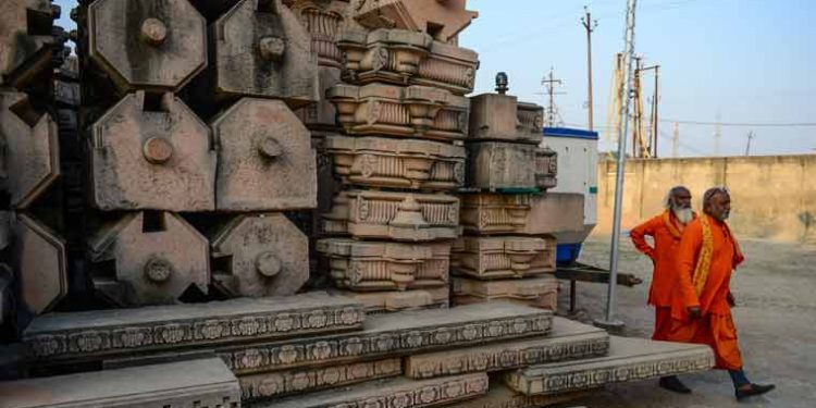 File photo of Hindu devotees walking past stone slabs earmarked for the construction of Ram temple at Ram Janmabhoomi Nyas workshop in Ayodhya (Source: AFP)