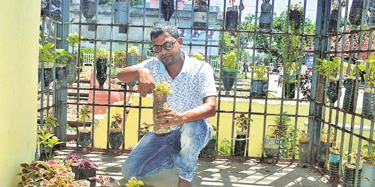 This railway department employee makes best use of discarded plastic drinking water bottles