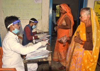 Rohtas: Polling officials check the names of voters at a polling booth as they arrive to cast their votes for the first phase of Bihar Assembly Election, amid the coronavirus pandemic, at Chenari police station in Rohtas district, Wednesday, Oct. 28, 2020. (PTI Photo)