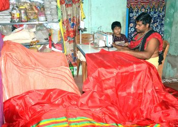 File photo of a Dorjee servitor stitching winter clothes for Srimandir deities.