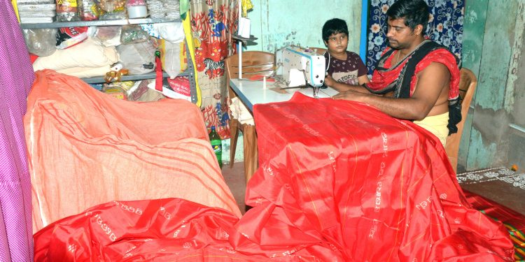 File photo of a Dorjee servitor stitching winter clothes for Srimandir deities.