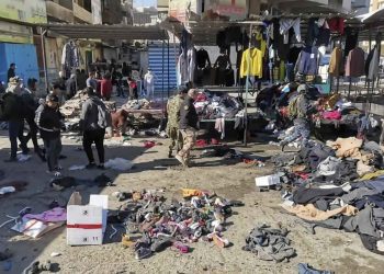 People and security forces gather at the site of a deadly bomb attack in a market selling used clothes, Iraq, Thursday, Jan. 21, 2021. Twin suicide bombings hit Iraq's capital Thursday killing and wounding civilians, police and state TV said. (AP Photo/Hadi Mizban)