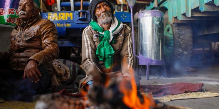 File photo of farmers warming themselves near a bonfire during their ongoing agitation against new farm laws in New Delhi