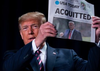 FILE – In this February 6, 2020, file photo, President Donald Trump holds up a newspaper with the headline that reads “ACQUITTED” at the 68th annual National Prayer Breakfast, at the Washington Hilton in Washington. (AP Photo/ Evan Vucci, File)