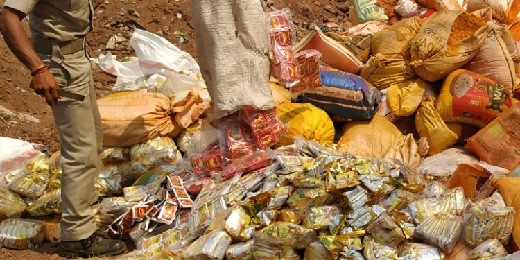 A Malgodown police official disposing of a huge amount of adulterated spice packets near Sikharpur area in Cuttack, Monday