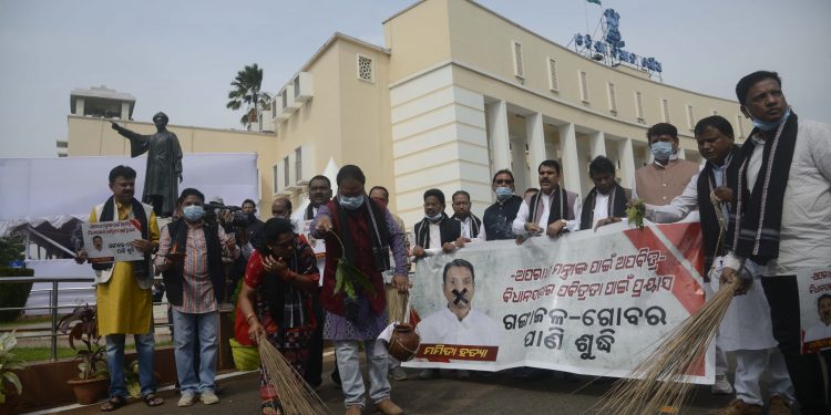 BJP MLAs sprinkle ‘Ganga Jal’ in front of the Assembly building and sweep the place as part of their protest over Mamita Meher murder case,