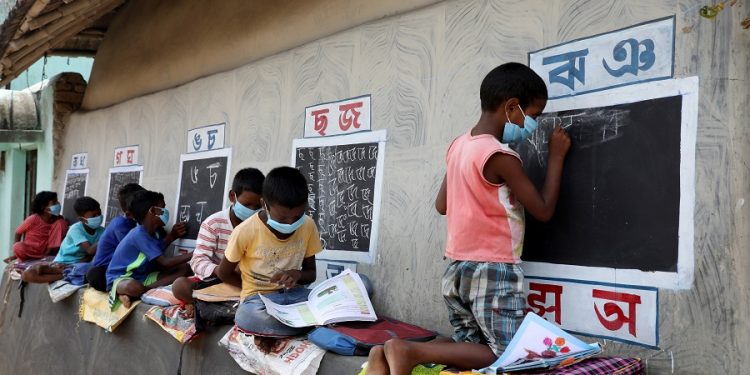 Children, who do not have access to internet facilities and gadgets, attend an open-air class outside the houses with the walls converted into black boards following the closure of their schools due to the coronavirus disease outbreak, at Joba Attpara village in Paschim Bardhaman district, West Bengal. (PC: Reuters/Rupak De Chowdhuri)