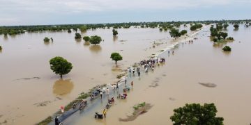 People walk through floodwaters after heavy rainfall in Hadeja, Nigeria Sept 19, 2022. Nigeria is battling its worst floods in a decade (PC: AP)