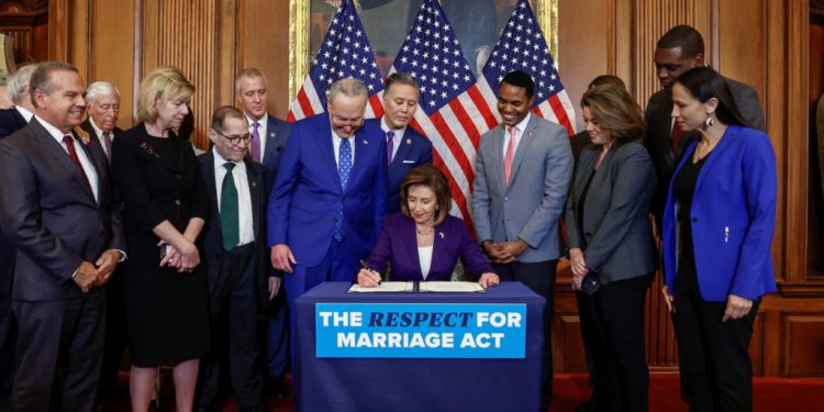 U.S. House Speaker Nancy Pelosi (D-CA) signs "The Respect for Marriage Act" alongside fellow members of Congress, during a bill enrollment ceremony on Capitol Hill, in Washington, U.S., December 8, 2022. REUTERS/Evelyn Hockstein