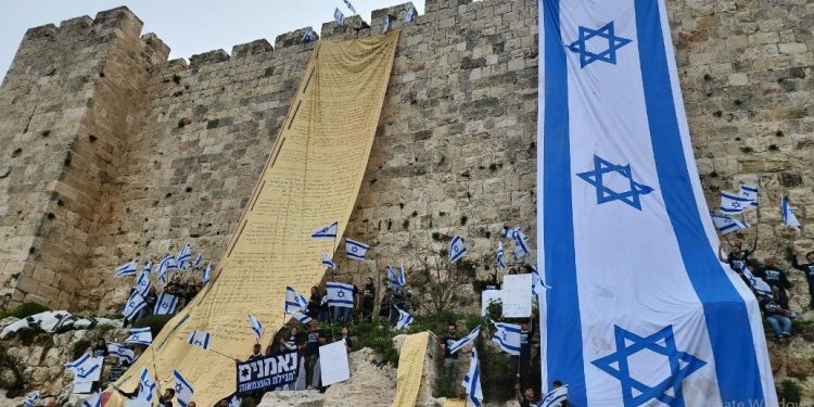 Protestors hanging Israeli National flag and the Declaration of Independence from the walls of Jerusalem (Image: Democrats_IL/Twitter)