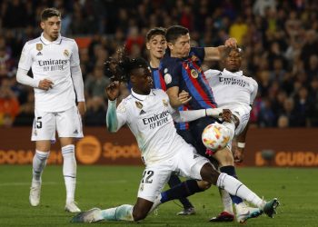 FILE - Barcelona's Robert Lewandowski, center, is challenged by Real Madrid's Eduardo Camavinga, left, and Real Madrid's David Alaba during the Spanish Copa del Rey semifinal, second leg soccer match between Barcelona and Real Madrid at the Camp Nou stadium in Barcelona, Spain, Wednesday, April 5, 2023. Barcelona will open its Spanish league title defense at Getafe when the competition returns to action in mid-August. Real Madrid will visit Barcelona’s Olympic Stadium on the weekend of Oct. 28-29 in the first classic played away from Camp Nou while Europe’s largest soccer stadium undergoes renovations. (AP Photo/Joan Monfort, File)