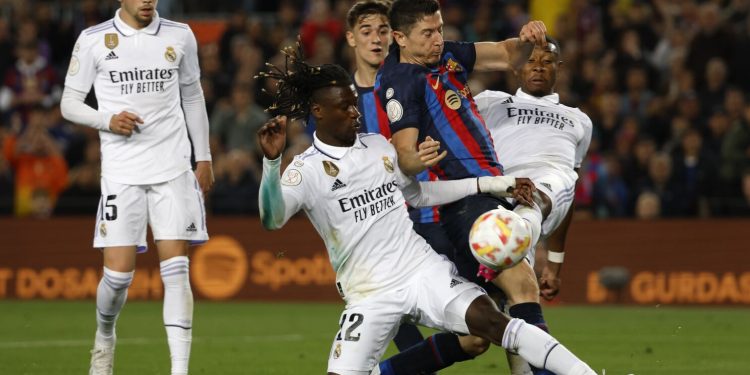 FILE - Barcelona's Robert Lewandowski, center, is challenged by Real Madrid's Eduardo Camavinga, left, and Real Madrid's David Alaba during the Spanish Copa del Rey semifinal, second leg soccer match between Barcelona and Real Madrid at the Camp Nou stadium in Barcelona, Spain, Wednesday, April 5, 2023. Barcelona will open its Spanish league title defense at Getafe when the competition returns to action in mid-August. Real Madrid will visit Barcelona’s Olympic Stadium on the weekend of Oct. 28-29 in the first classic played away from Camp Nou while Europe’s largest soccer stadium undergoes renovations. (AP Photo/Joan Monfort, File)