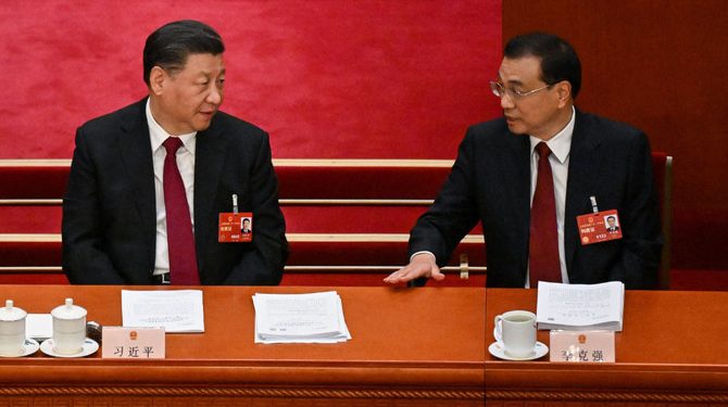 Xi Jinping (L) speaks with Li Keqiang during the opening session of the National People's Congress at the Great Hall of the People in Beijing March 5, 2023. (PC: AFP)