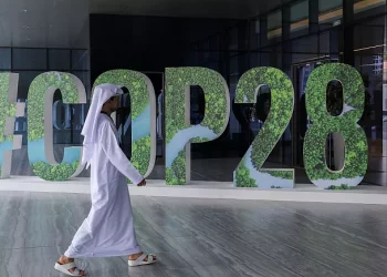 A person walks past a '#COP28' sign during an event in Abu Dhabi, United Arab Emirates. (PC: REUTERS)