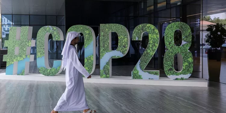 A person walks past a '#COP28' sign during an event in Abu Dhabi, United Arab Emirates. (PC: REUTERS)