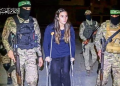 Hamas fighters accompany a newly released Israeli hostage to a Red Cross vehicle in the Gaza Strip on Sunday. (AFP)