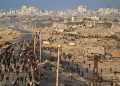 Israeli tanks are positioned on the coastal road leading to Gaza City as displaced Palestinians gather near Wadi Gaza in the central Gaza Strip, Thursday, Oct. 9, 2025. (AP Photo/Abdel Kareem Hana)