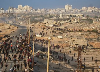 Israeli tanks are positioned on the coastal road leading to Gaza City as displaced Palestinians gather near Wadi Gaza in the central Gaza Strip, Thursday, Oct. 9, 2025. (AP Photo/Abdel Kareem Hana)