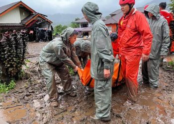 Rescuers carry the body of a flood victim in Malalak, West Sumatra, Indonesia, Friday, Nov. 28, 2025. (AP Photo/Ade Yuandha)
