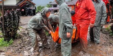Rescuers carry the body of a flood victim in Malalak, West Sumatra, Indonesia, Friday, Nov. 28, 2025. (AP Photo/Ade Yuandha)