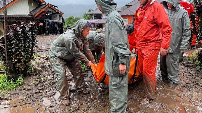 Rescuers carry the body of a flood victim in Malalak, West Sumatra, Indonesia, Friday, Nov. 28, 2025. (AP Photo/Ade Yuandha)